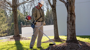 A person uses a Honda brush trimmer outside.  